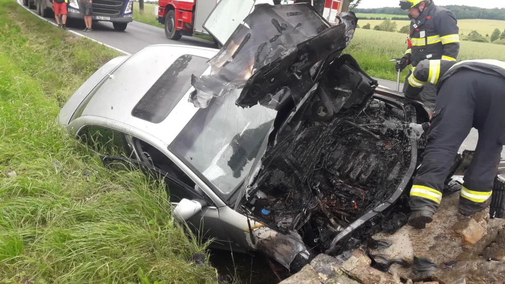Audi čelně narazilo do betonového propustku a okamžitě začalo hořet v motorové části. Dva lidé se zranili