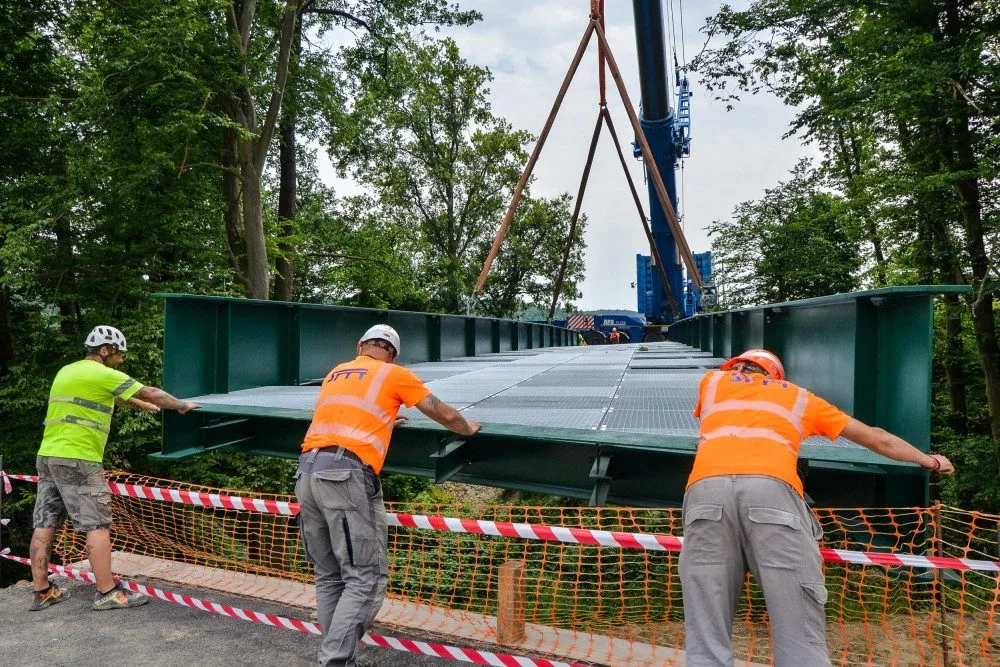 Nepoužívaná mostní konstrukce překlenula problematickou rokli, kde vzniká nový úsek stezky pro pěší i cyklisty