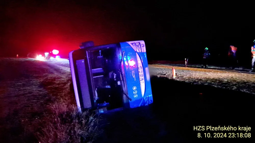 Autobus se převrátil na bok do příkopu. Dostal smyk na silnici, kterou silně znečistila vrstv kluzkého bahna