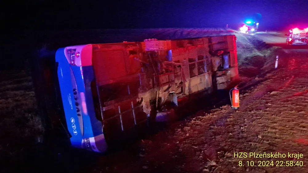 Autobus se převrátil na bok do příkopu. Dostal smyk na silnici, kterou silně znečistila vrstv kluzkého bahna