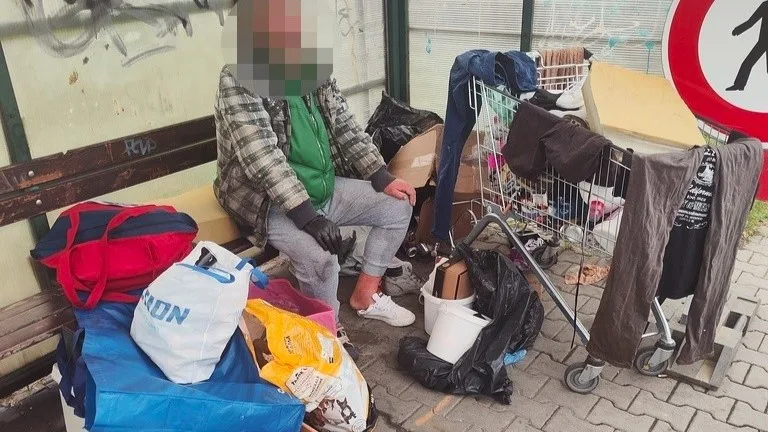 Bezdomovci si budují příbytky přímo v ulicích města. Jeden obsadil zastávku MHD se svým mobiliářem