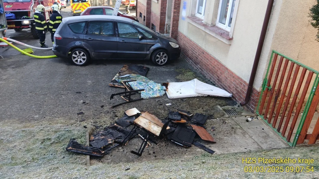 Hasiči zachraňovali pomocí žebříku nájemníky domu, které tam uvěznil požár jednoho bytu