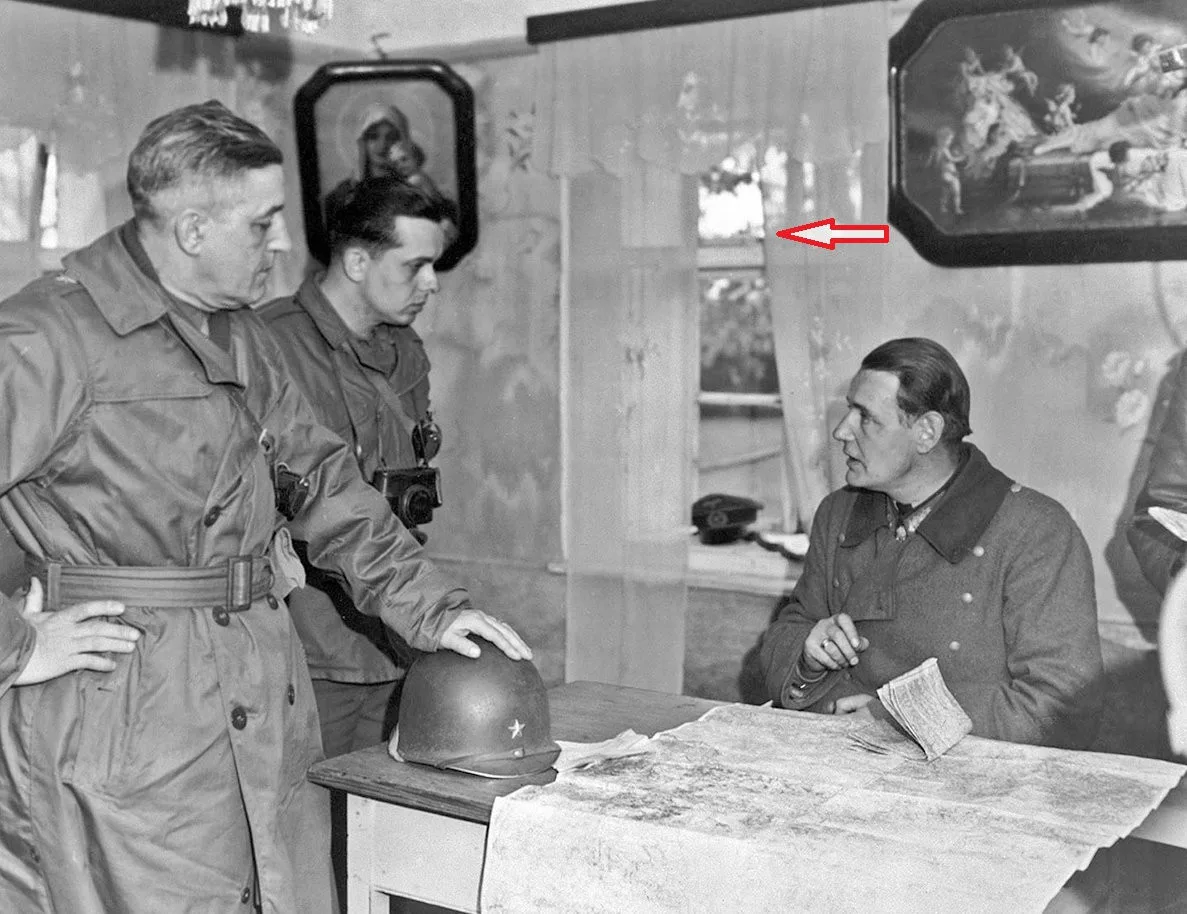 Velitel 90. pěší divize genmjr. Earnest dojednává podmínky kapitulace divize. Vedle generála stojí kapitán, který tlumočí. Sedící genpor. von Wietersheim. Šipka ukazuje, že skrze okno je vidět silueta kostelíka sv. Anny