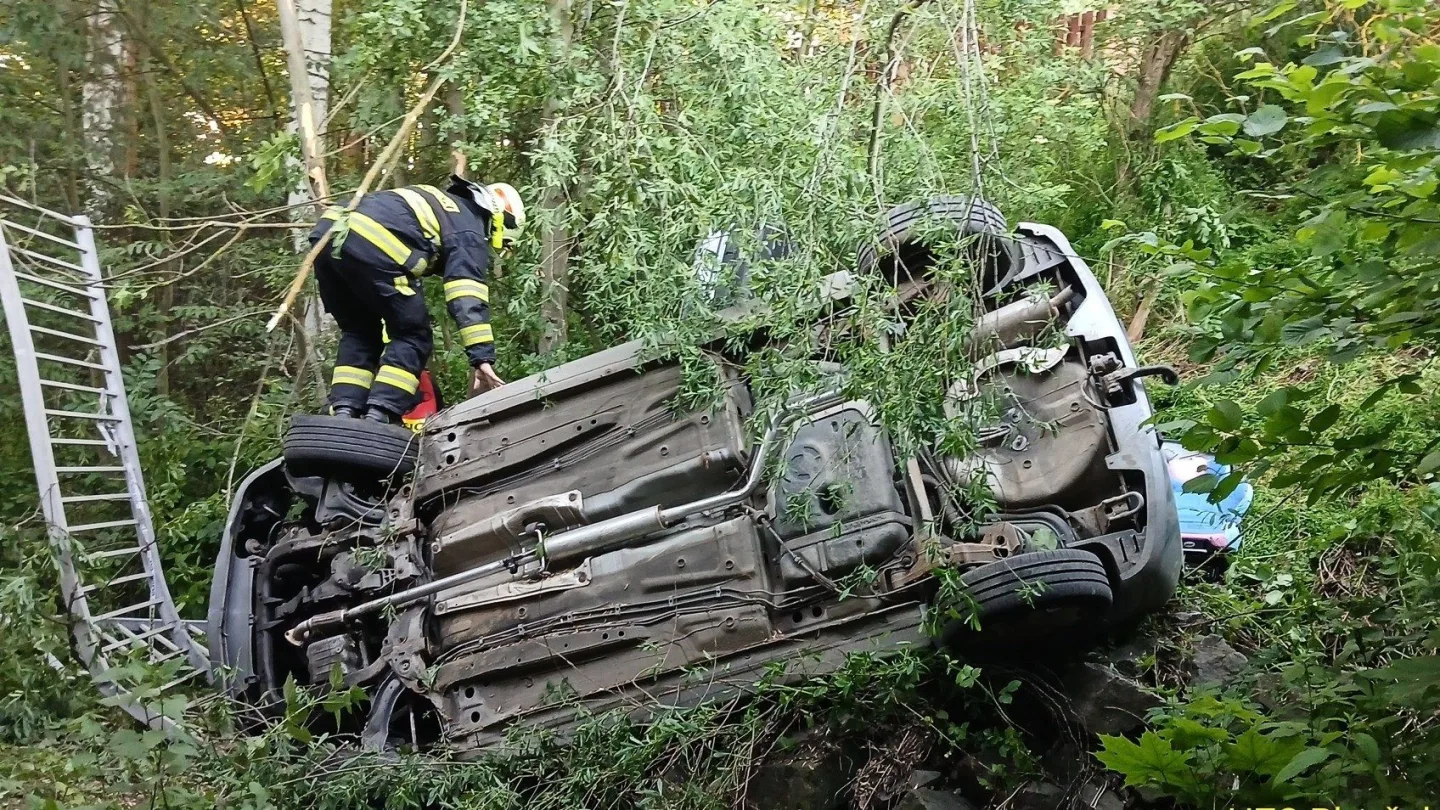 Auto vyletělo ze silnice, prorazilo zábradlí a zřítilo se ze srázu do koryta potoka