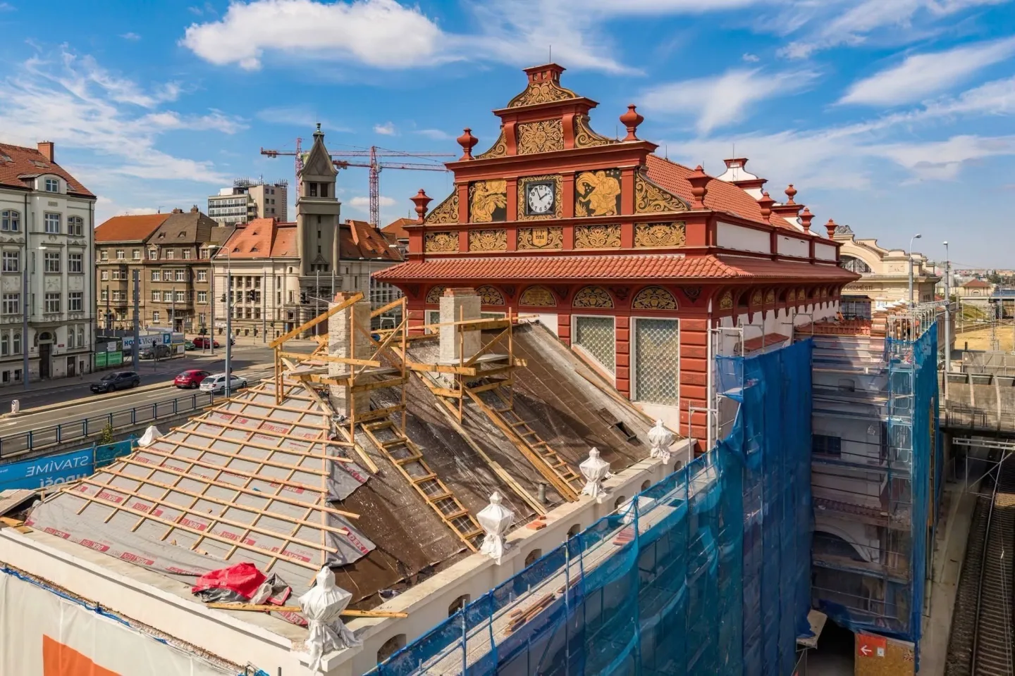 Fasáda nádražní budovy z roku 1921 září novotou. V hale už montují nové luxfery
