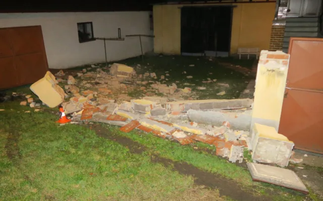 Auto zbořilo hradbu a přistálo na střeše ve vjezdu dalšího domu, řidič od nehody ujel jiným vozem