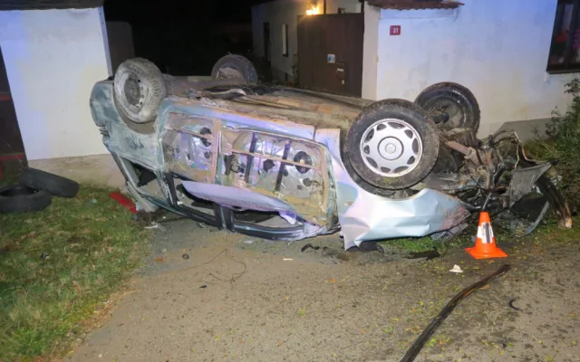 Auto zbořilo hradbu a přistálo na střeše ve vjezdu dalšího domu, řidič od nehody ujel jiným vozem