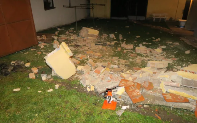 Auto zbořilo hradbu a přistálo na střeše ve vjezdu dalšího domu, řidič od nehody ujel jiným vozem