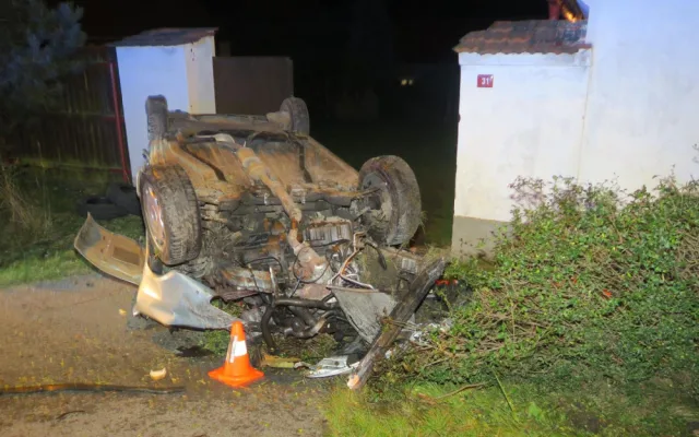 Auto zbořilo hradbu a přistálo na střeše ve vjezdu dalšího domu, řidič od nehody ujel jiným vozem