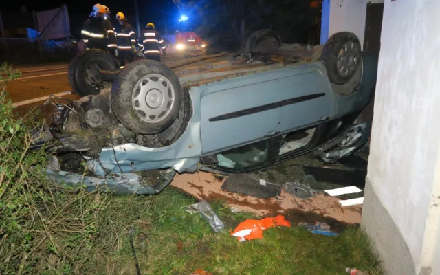 Auto zbořilo hradbu a přistálo na střeše ve vjezdu dalšího domu, řidič od nehody ujel jiným vozem