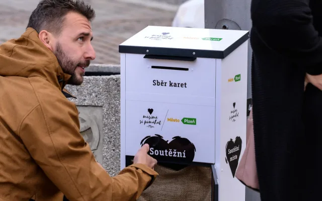 Lidé vhazují vyplněné hrací karty do speciální schránky na náměstí Republiky