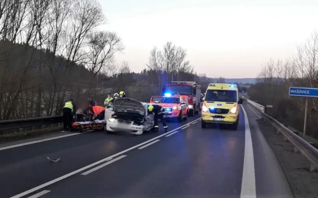 Řidič BMW přejel do protisměru a srazil se s náklaďákem převážejícím stavební stroj
