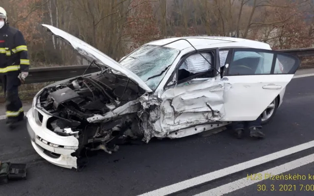 Řidič BMW přejel do protisměru a srazil se s náklaďákem převážejícím stavební stroj