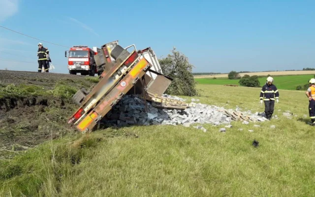 Auto najelo na nezpevněnou krajnici a zřítilo se za svahu, naložený stavební materiál se vsypal
