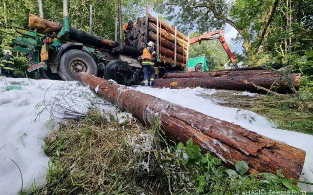 Kamion s nákladem dřeva náhle vzplál, statečný řidič dokázal hydraulickou rukou vyložit většinu hořících klád