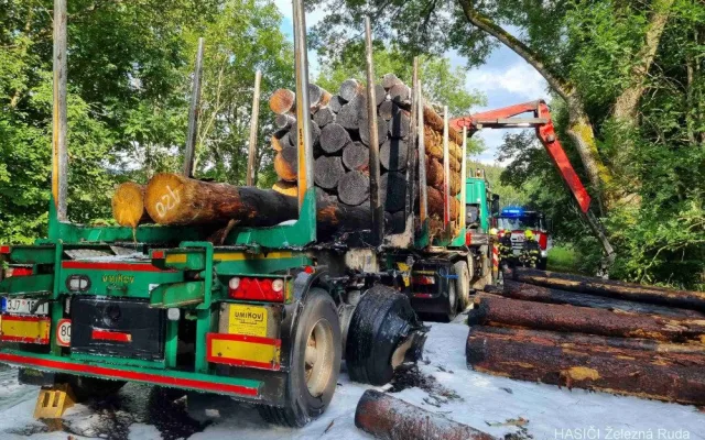 Kamion s nákladem dřeva náhle vzplál, statečný řidič dokázal hydraulickou rukou vyložit většinu hořících klád