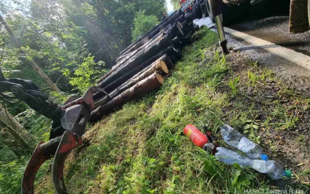 Kamion s nákladem dřeva náhle vzplál, statečný řidič dokázal hydraulickou rukou vyložit většinu hořících klád