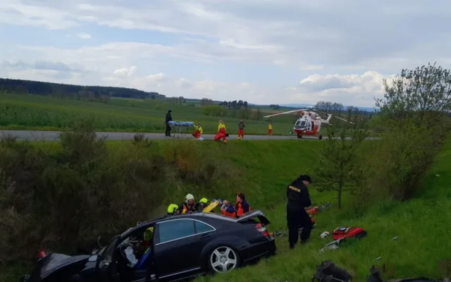 Při hrozivém čelním střetu luxusního mercedesu s nákladním vozidlem pro přepravu dřeva se těžce zranili dva lidé