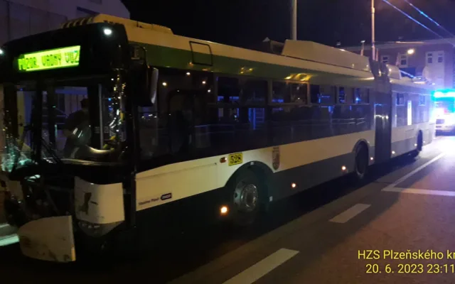 Trolejbus po střetu odmrštil osobní automobil přes chodník a zábradlí až na zeď s billboardem. Dva lidé se zranili