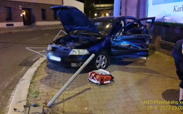 Trolejbus po střetu odmrštil osobní automobil přes chodník a zábradlí až na zeď s billboardem. Dva lidé se zranili