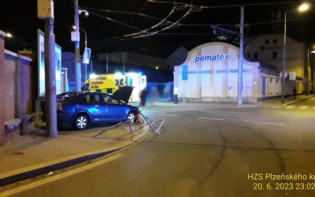 Trolejbus po střetu odmrštil osobní automobil přes chodník a zábradlí až na zeď s billboardem. Dva lidé se zranili