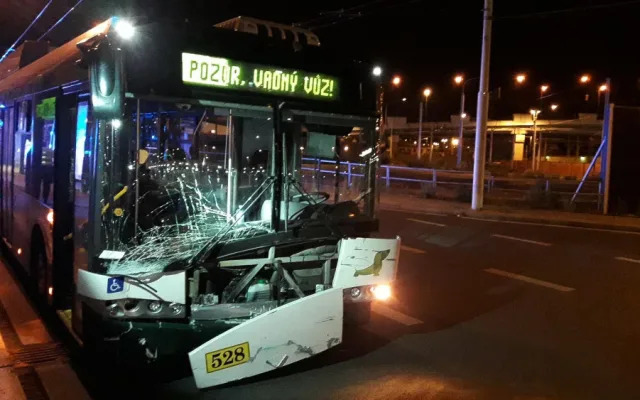 Trolejbus po střetu odmrštil osobní automobil přes chodník a zábradlí až na zeď s billboardem. Dva lidé se zranili
