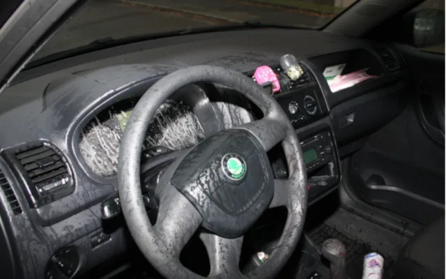 Následky útoku kyselinou v interiéru automobilu