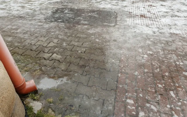 Okap končí přímo nad chodníkem a mění ho v nebezpečnou ledovou past na chodce