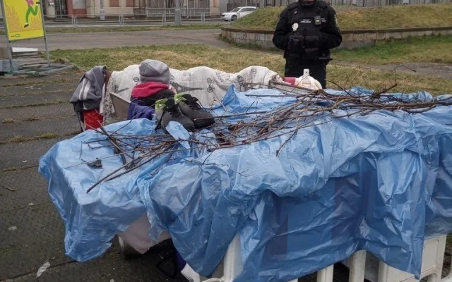 Dva bezdomovci si postavili ležení z bezpečnostních zábran na náměstí, sušili tam prádlo a rozdělávali oheň