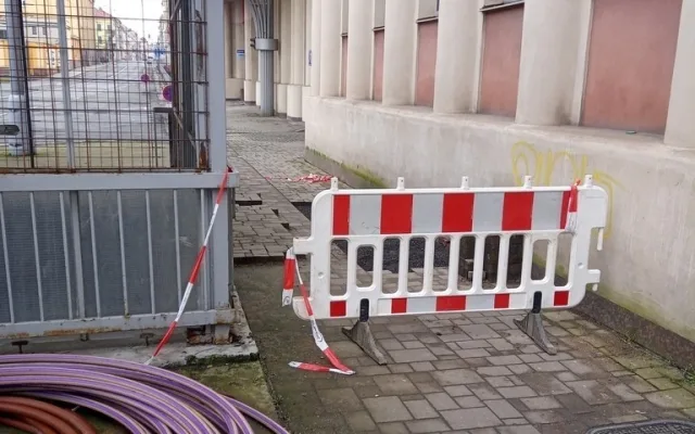 Dva bezdomovci si postavili ležení z bezpečnostních zábran na náměstí, sušili tam prádlo a rozdělávali oheň