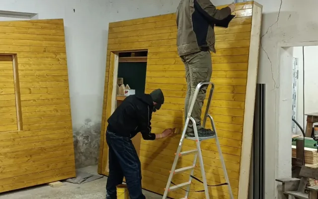 Bezdomovci pomáhají se stavbou mobilního domku, budou v něm pak přespávat