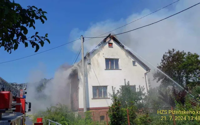 Na Domažlicku hoří hromada pneumatik a okolní budovy, ve vedru kolabují hasiči