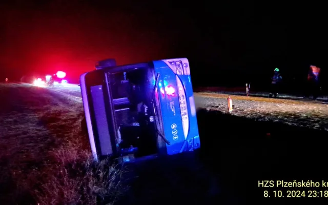 Autobus se převrátil na bok do příkopu. Dostal smyk na silnici, kterou silně znečistila vrstv kluzkého bahna