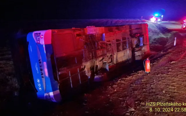 Autobus se převrátil na bok do příkopu. Dostal smyk na silnici, kterou silně znečistila vrstv kluzkého bahna