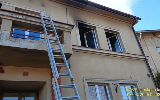 Hasiči zachraňovali pomocí žebříku nájemníky domu, které tam uvěznil požár jednoho bytu