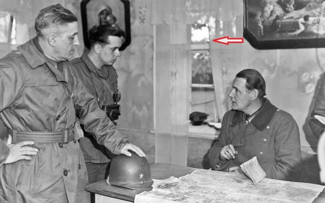 Velitel 90. pěší divize genmjr. Earnest dojednává podmínky kapitulace divize. Vedle generála stojí kapitán, který tlumočí. Sedící genpor. von Wietersheim. Šipka ukazuje, že skrze okno je vidět silueta kostelíka sv. Anny