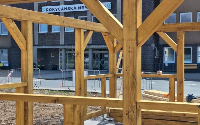Nevzhledná travnatá plocha před nemocnicí se mění v park s altánkem