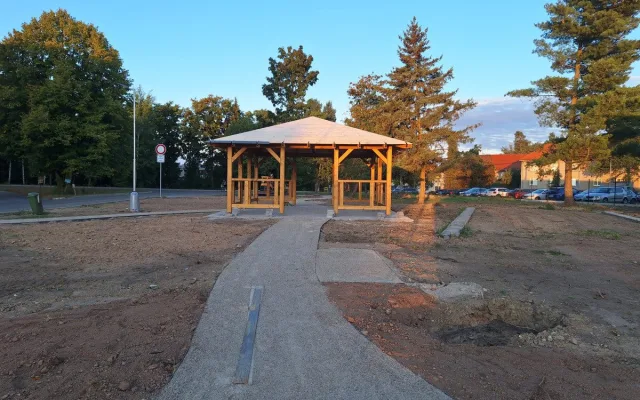 Nevzhledná travnatá plocha před nemocnicí se mění v park s altánkem