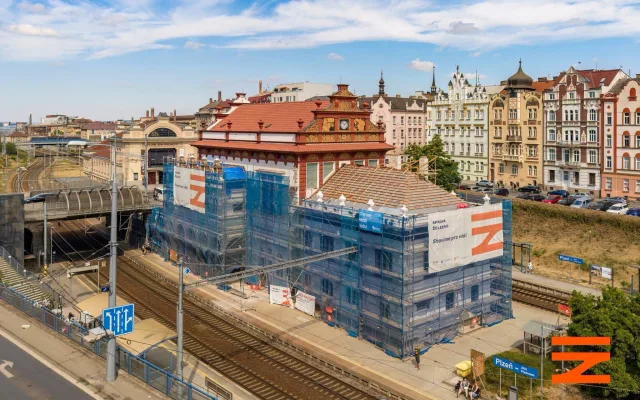Fasáda nádražní budovy z roku 1921 září novotou. V hale už montují nové luxfery