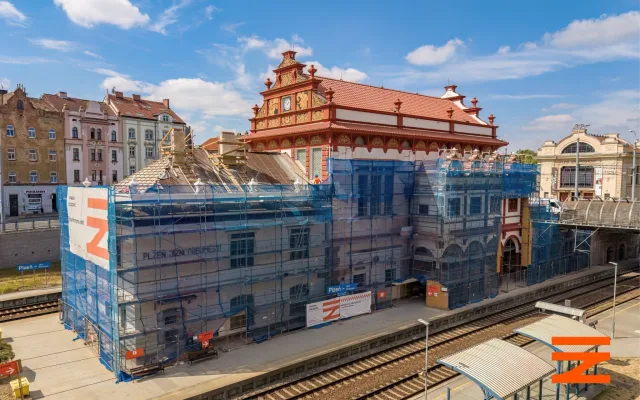 Fasáda nádražní budovy z roku 1921 září novotou. V hale už montují nové luxfery