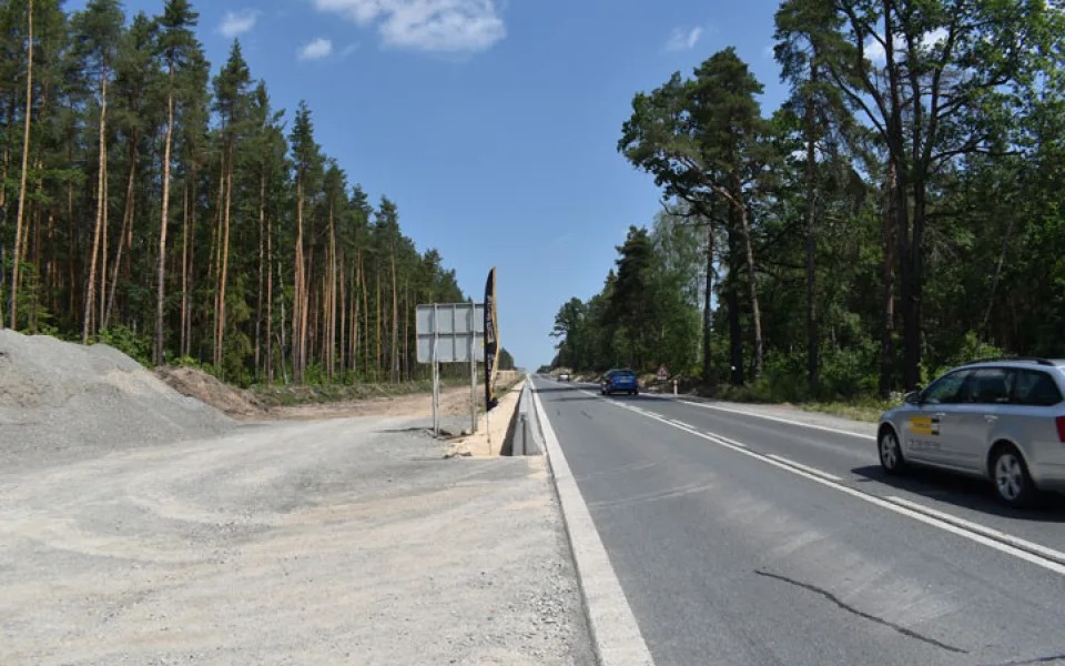 Tato komunikace se rozšiřuje na čtyři pruhy, překlene ji lávka, která povede i přes železniční trať