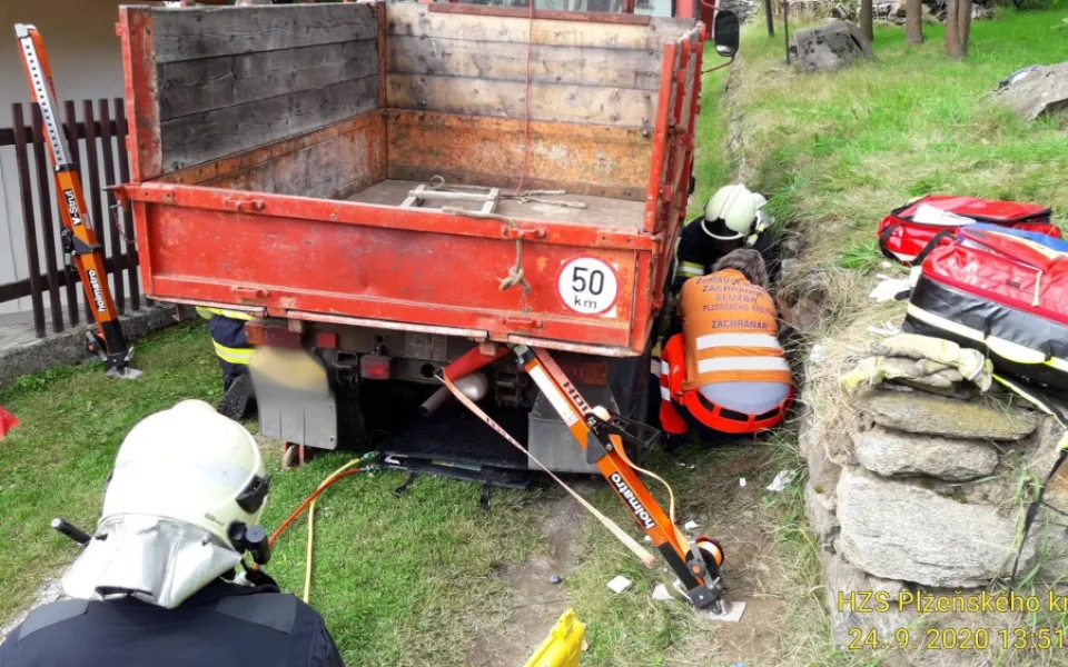 Hasiči a záchranáři vyprošťují muže z pod multikáry