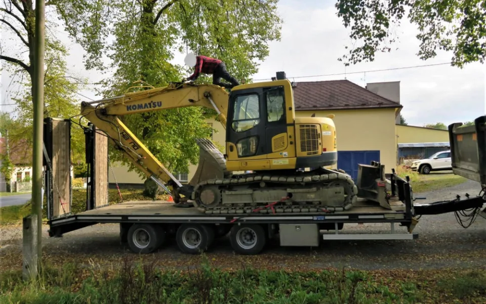 Řidič neodhadl výšku železničního podjezdu, naloženým bagrem ho poškodil