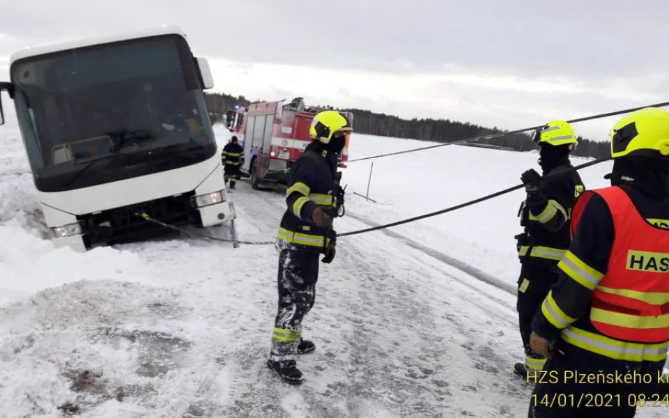 Hasiči vyprošťují autobus, který sjel do příkopu