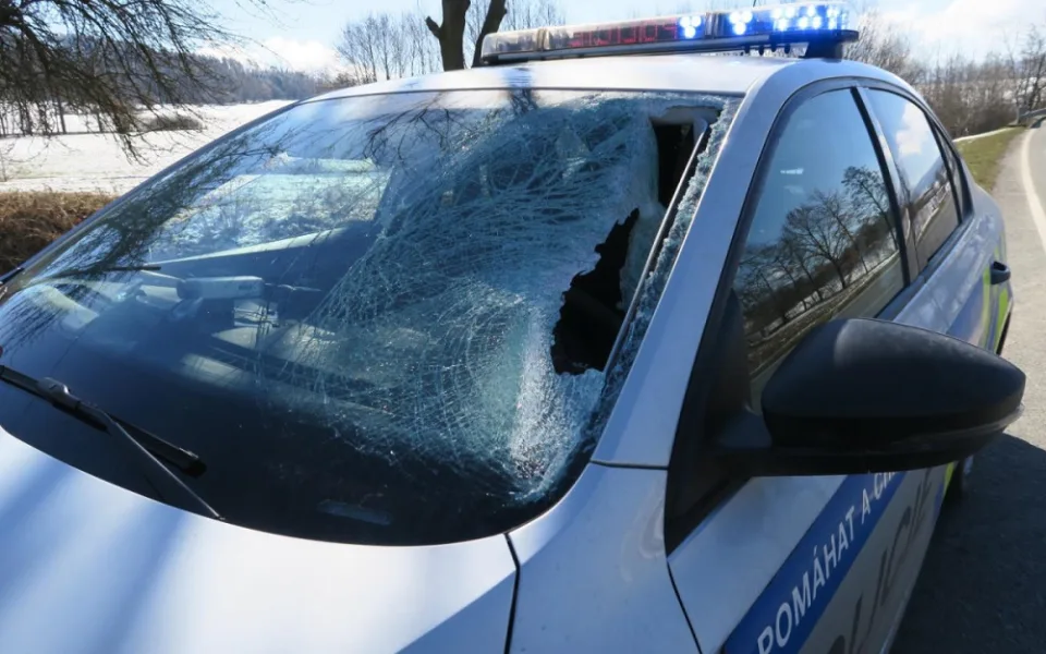 Kus ledu proletěl čelním sklem policejního vozu, jen těsně minul řidičku a spolujezdce