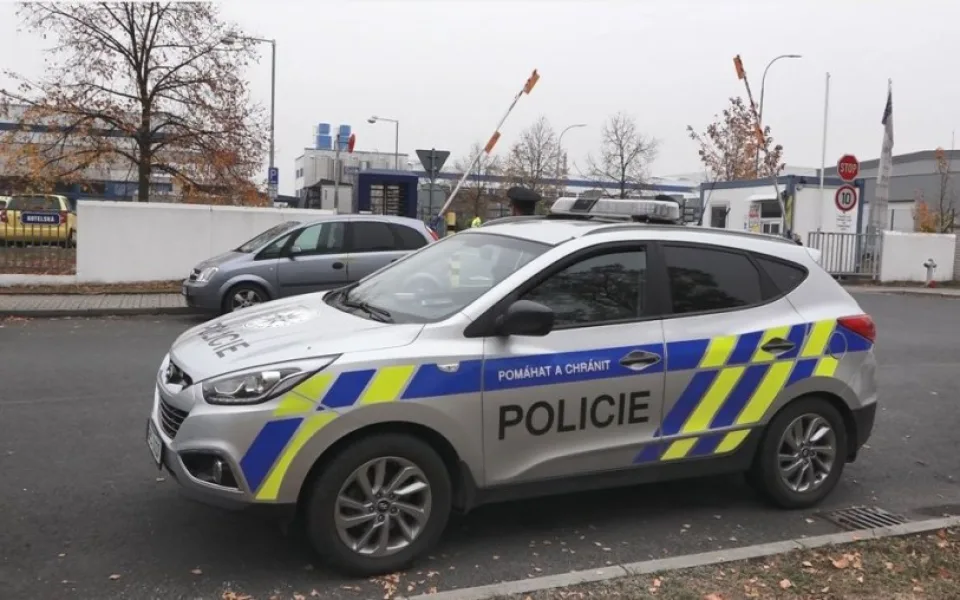 Policisté na místě tragické střelby. V pozadí je vůz, ve které seděla oběť