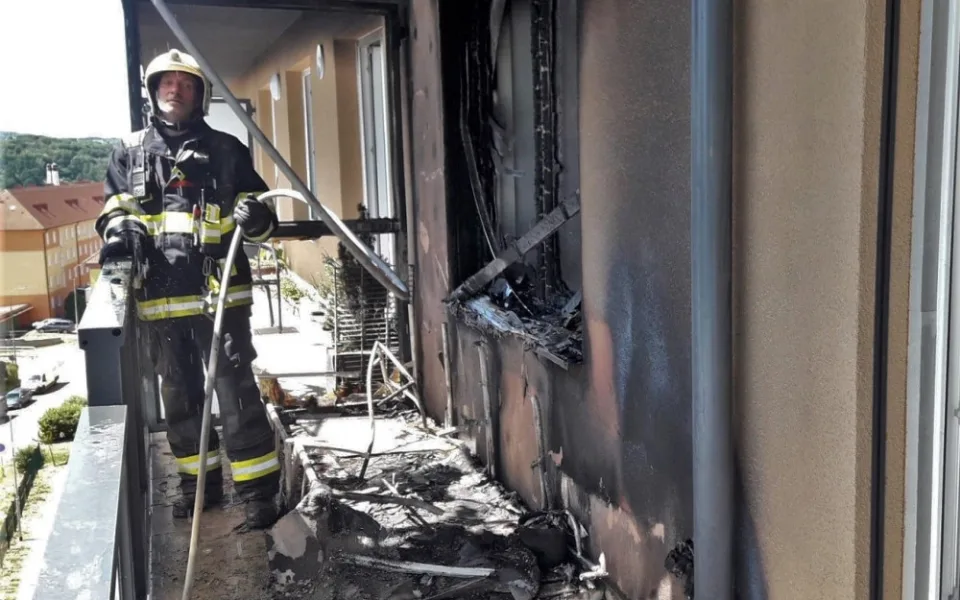 Obyvatelé bytového domu opustili kvůli požáru své domovy, jeden hasič při zásahu zkolaboval
