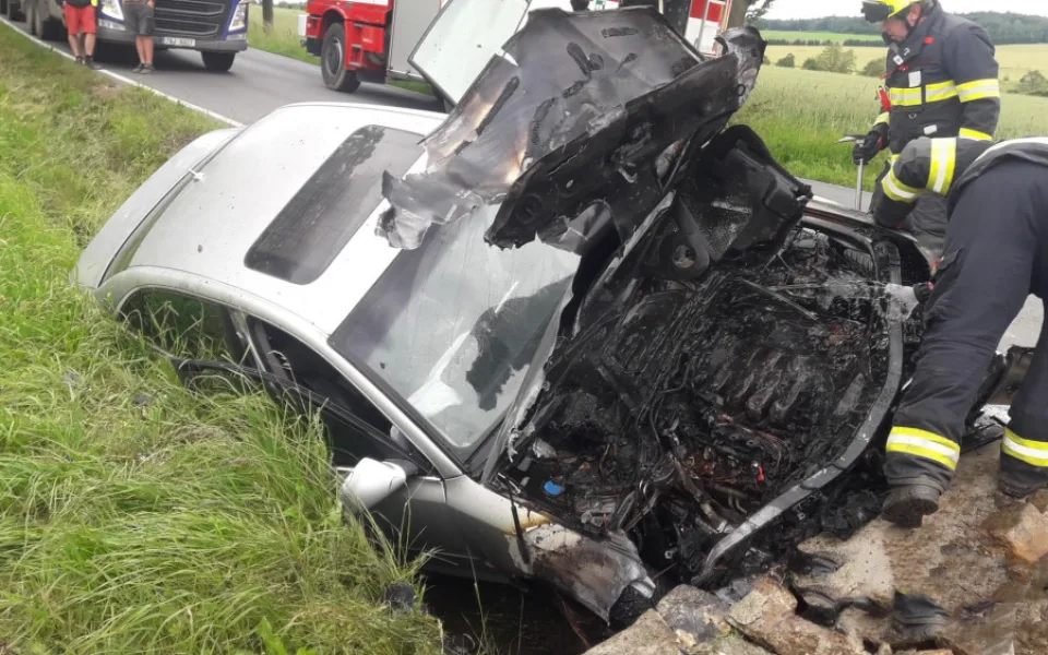 Audi čelně narazilo do betonového propustku a okamžitě začalo hořet v motorové části. Dva lidé se zranili