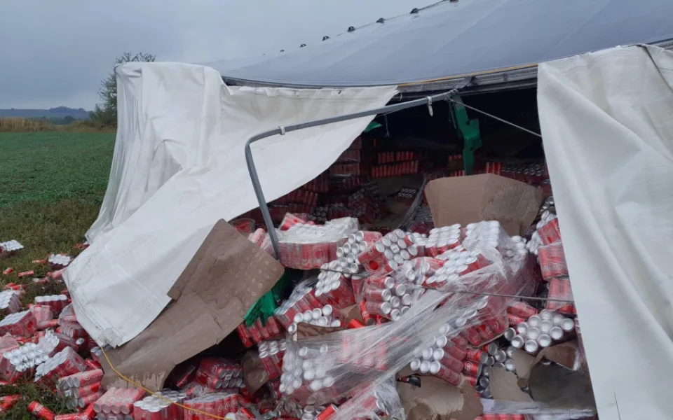 Na pole se vysypaly stovky plechovek Coca-Coly z převráceného kamionu