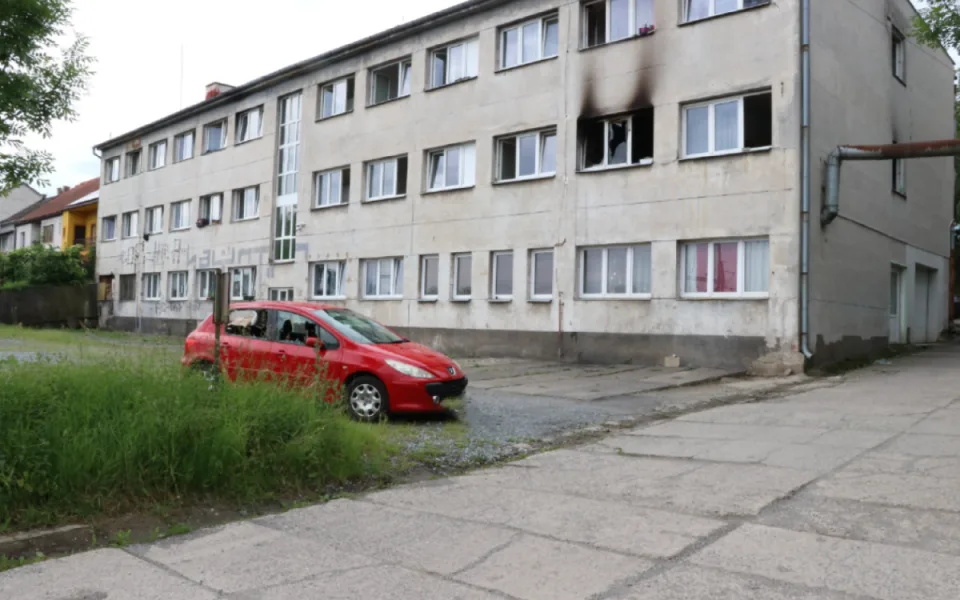 Ze msty muž zapálil ubytovnu, kladivem zdemoloval auto a ohrozil životy 68 lidí